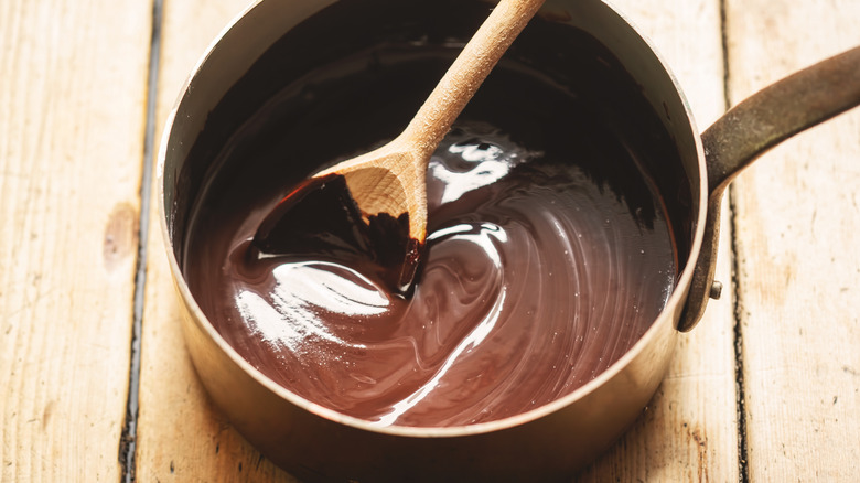 chocolate sauce in pan with wooden spoon