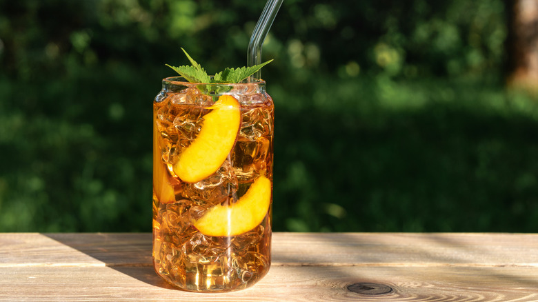 peach iced tea in glass on outdoor table