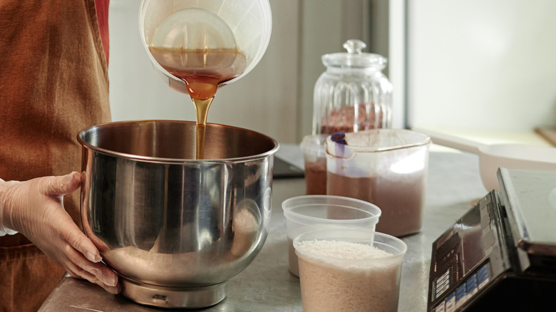 woman pouring maple syrup into mixing bowl