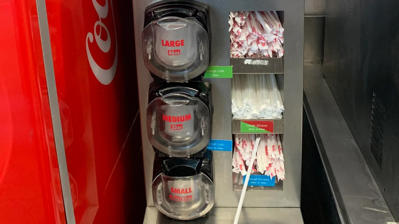 Lids and straws for fountain drinks next to Coca Cola Freestyle soda machine at Wawa convenience store