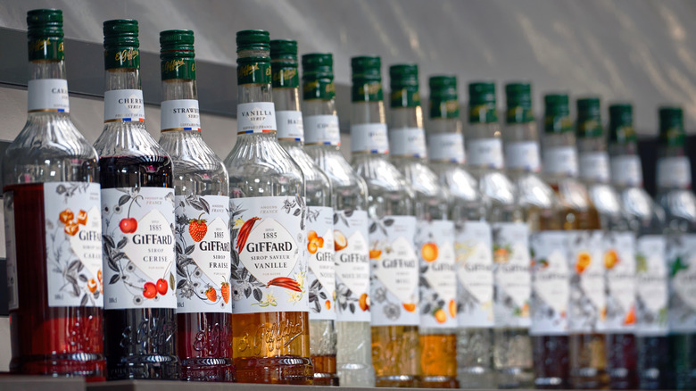 A row of glass flavored syrup bottles