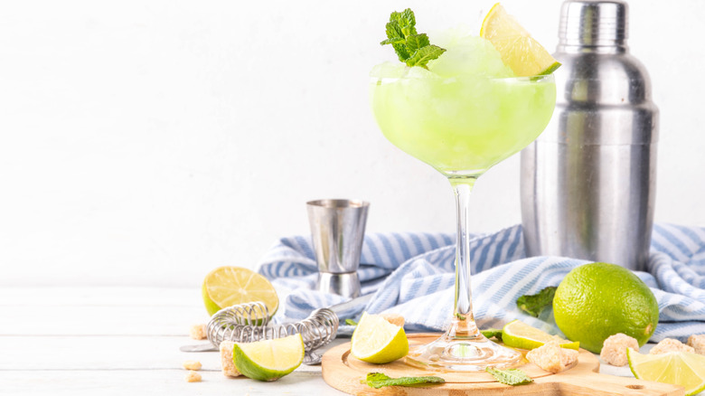 A cocktail glass of lemonade and a metal shaker