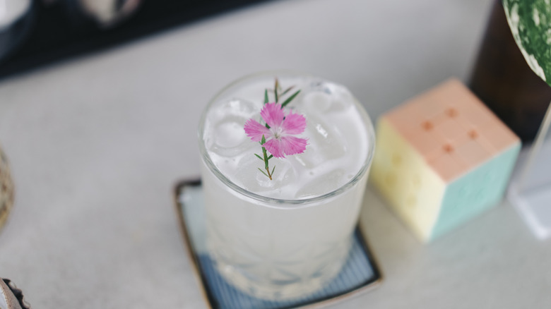 A glass of lemonade topped with an edible flower