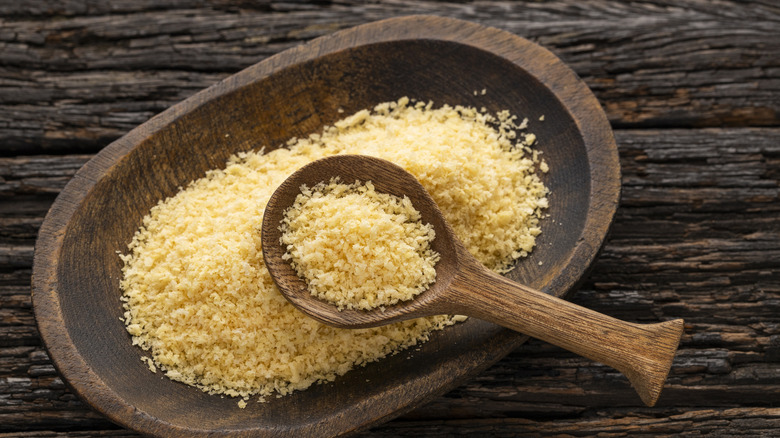 A wood bowl of panko crumbs on a wood table
