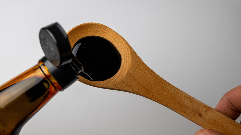 Soy sauce poured into a wooden spoon
