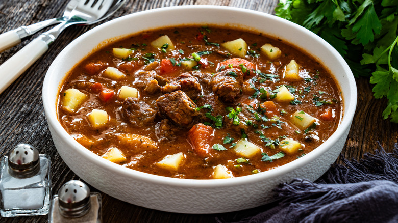 A white bowl of goulash soup