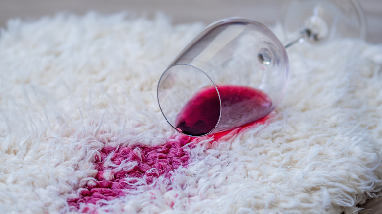 Spilled red wine glass on the white carpet