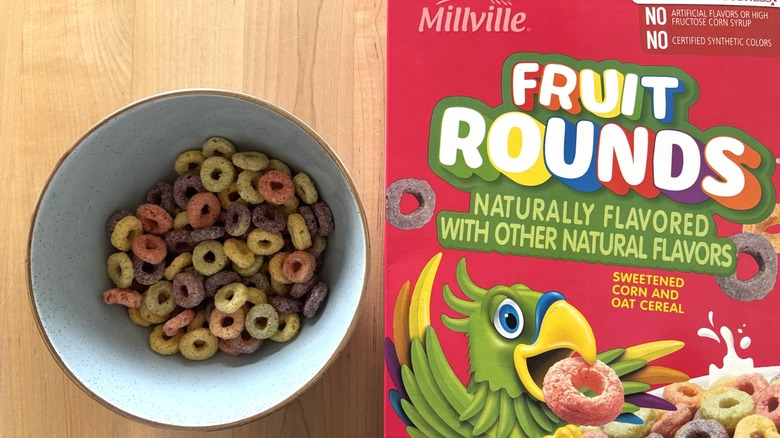 A bowl of colorful cereal next to a box of Fruit Rounds