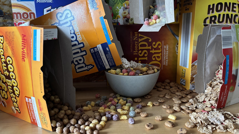 Open cereal boxes spilling cereal into a bowl and on the counter