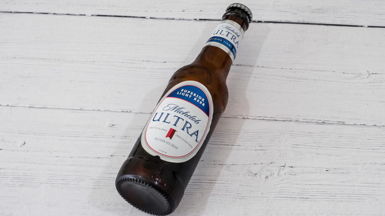 A bottle of Michelob Ultra on a white wooden background