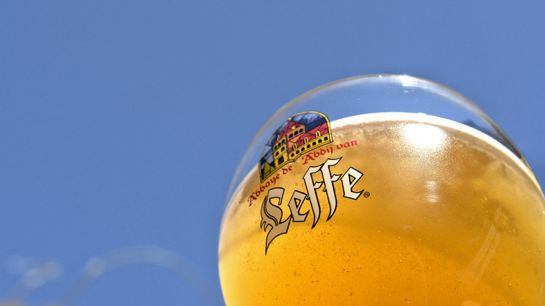 A glass of Leffe Blonde against the blue sky