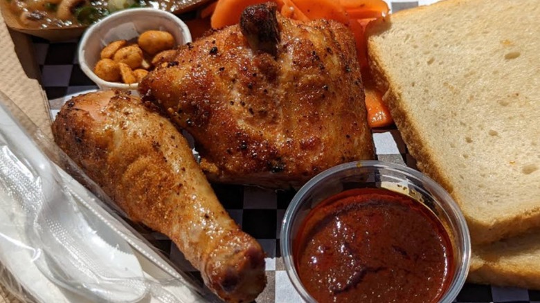 smoked chicken thigh and leg from distant relatives barbecue stand next to its famous chili vinegar sauce, bread, carrots, peanuts, and pinto beans