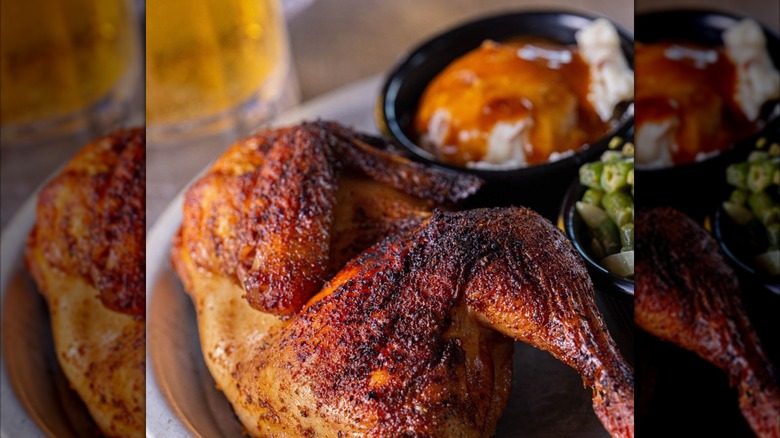 barbecued half chicken from shiver's barbecue next to sides of greens and mashed potatoes with gravy