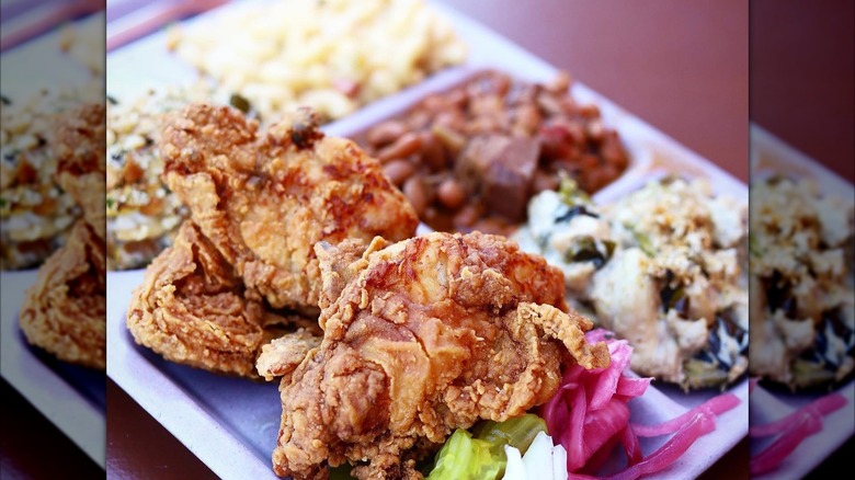 tray of Slow Bone BBQ's smoked water brine fried chicken with pickles, pickled onions, and sides