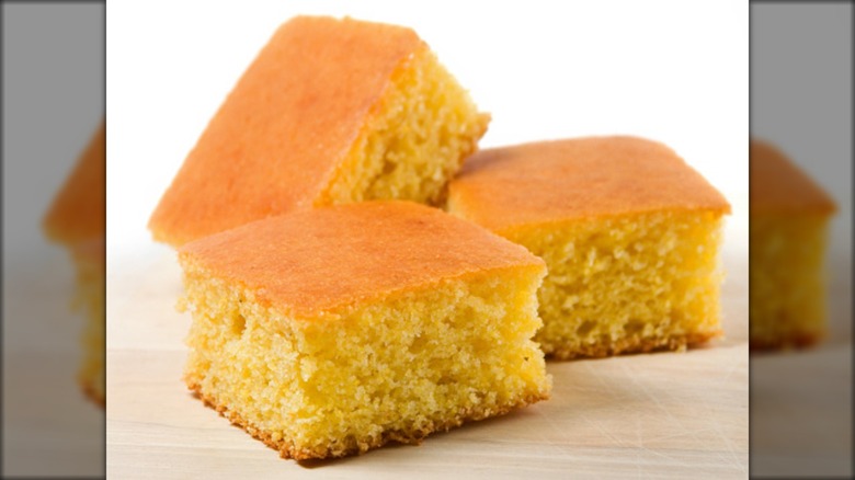 Three squares of cornbread posed against a white background