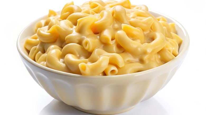 Creamy mac and cheese in a bowl, isolated on white background