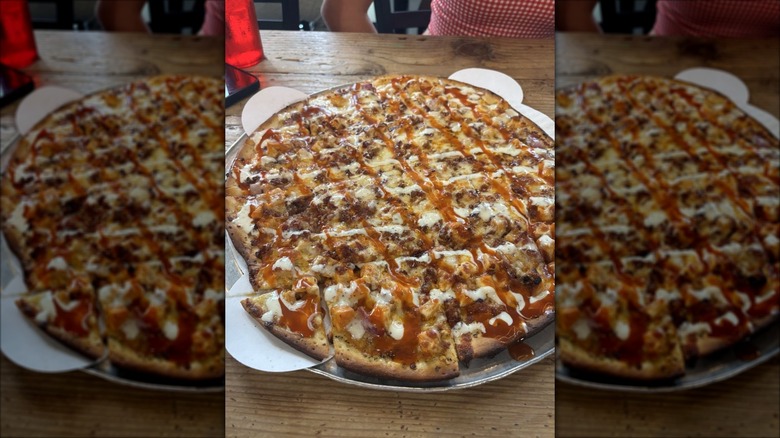 A Daredevil Hall tavern-style bacon, chicken, buffalo sauce, and ranch pizza, cut into squares