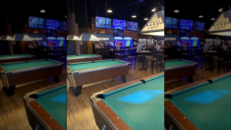 The pool table area of a Timeout Sports Bar, showing three tables with Coors Light lights hanging above