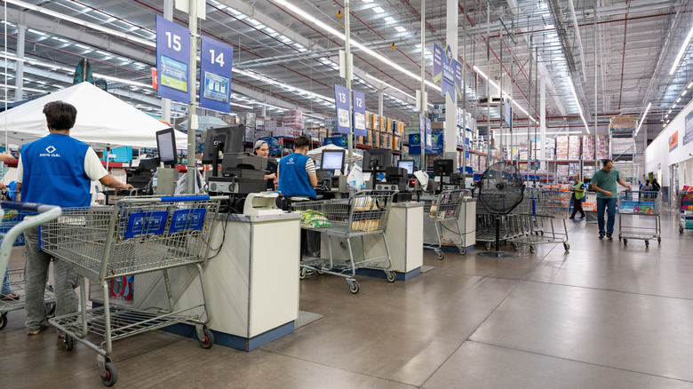 A view of checkout lanes at Sam's Club with people walking around.