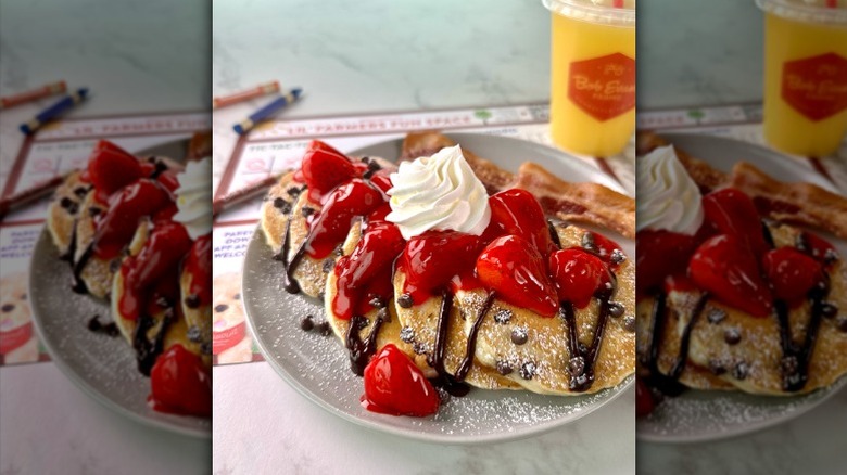 Pancakes with chocolate syrup, strawberries, and whipped cream on gray plate at Bob Evans