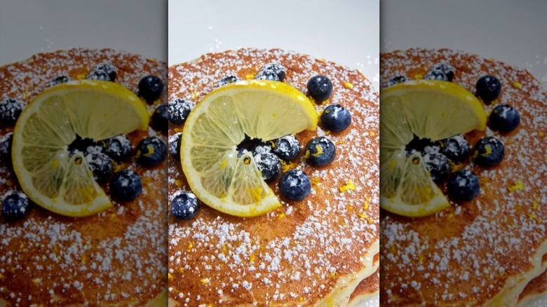 Pancakes toped with lemon, powdered sugar, and blueberries