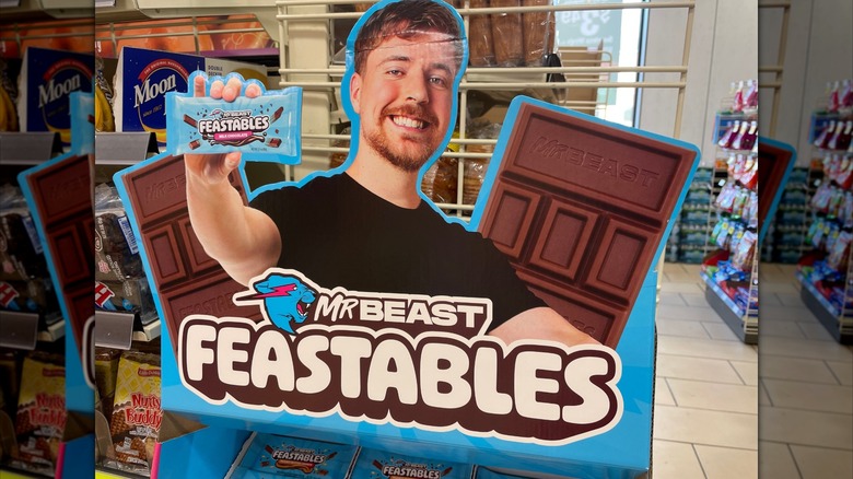 Cardboard cutout of Mr. Beast smiling and holding out a candy bar in an in-store display