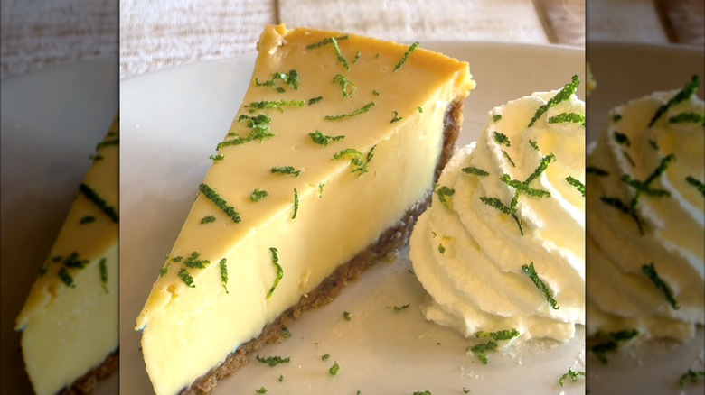 A slice of key lime pie and whipped cream covered in lime zest.