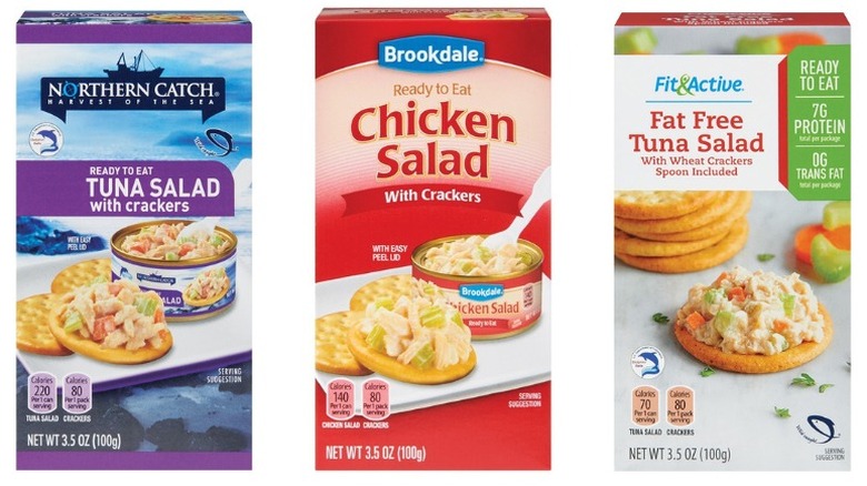 Packages of Brookdale Ready to Eat Chicken Salad with Crackers, Northern Catch Ready to Eat Tuna Salad with Crackers, and Fit & Active Fat Free Tuna Salad with Wheat Crackers on a white background