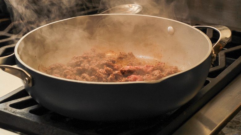 brown ground beef cooking in deep pan on stovetop