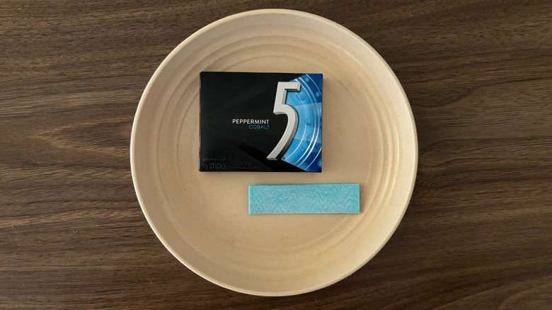 5 Peppermint Cobalt Sugar Free Chewing Gum and pieces of gum on round beige plate