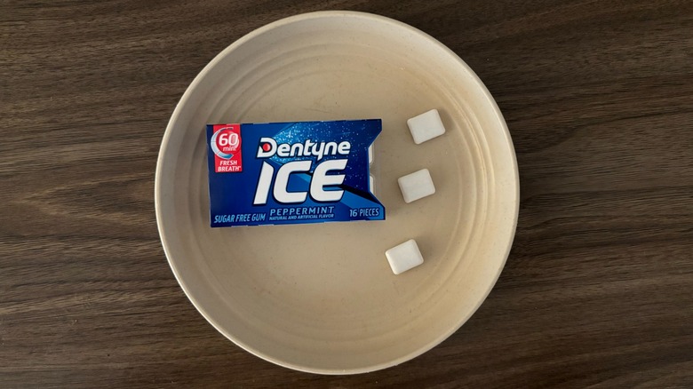 Dentyne Ice Peppermint Sugar Free Gum and pieces of gum on round beige plate
