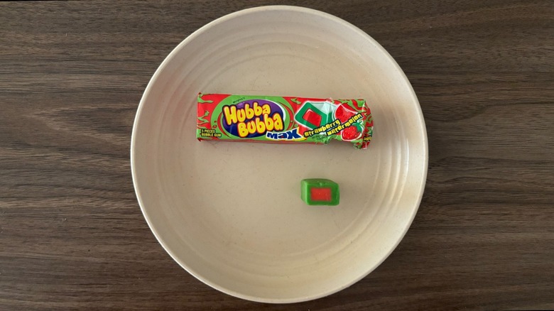 Hubba Bubba Max Strawberry Watermelon Bubble Gum packaging and piece of gum on round beige plate