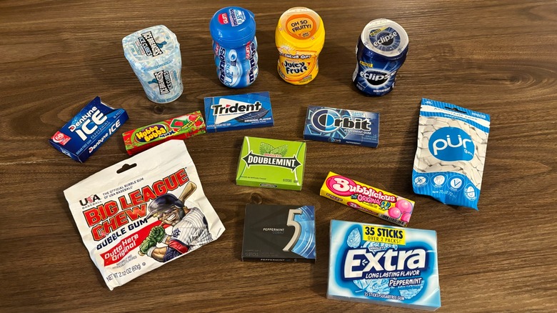 Several different chewing gum packages arranged on a wooden surface