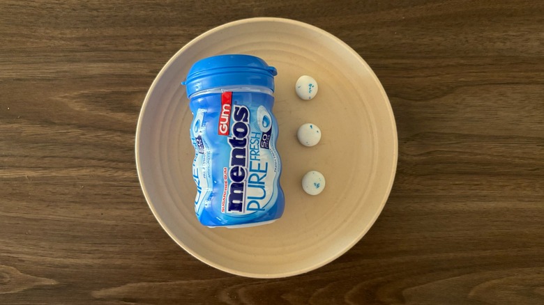 Mentos Pure Fresh Mint Sugar-Free Gum and pieces of gum on round beige plate