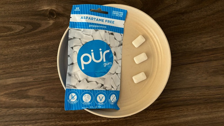 Pur Aspartame-Free Peppermint Gum packaging and pieces of gum on round beige plate