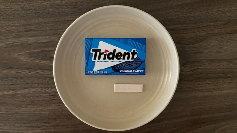 Trident Original Sugar Free Chewing Gum and pieces of gum on round beige plate