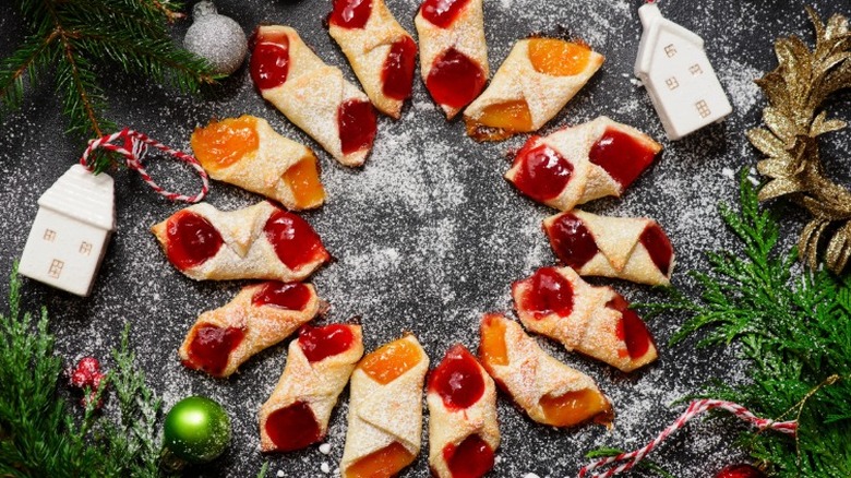 polish kolaczki cookies filled with orange and red jam arranged in a circle surrounded by christmas decorations
