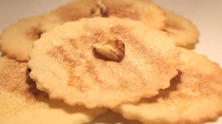 a stack of pennsylvania dutch sand tarts with cinnamon sugar and a walnut piece at the center of each