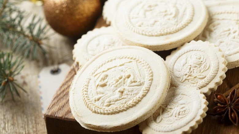 german springerle, circular white cookies with intricate designs of people and flowers embossed on them