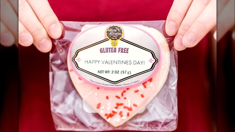 Hands holding heart-shaped Valentine's Day cookie