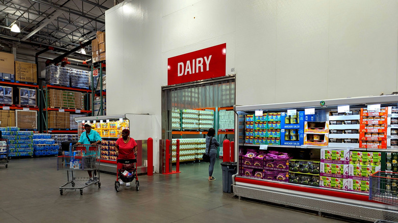 Shoppers walking through refrigerated dairy aisle entrance at costco