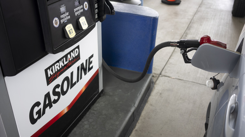 A car being refueled at a Kirkland Signature Gasoline pump