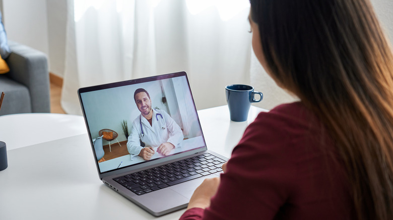 A patient talking to a doctor on a laptop