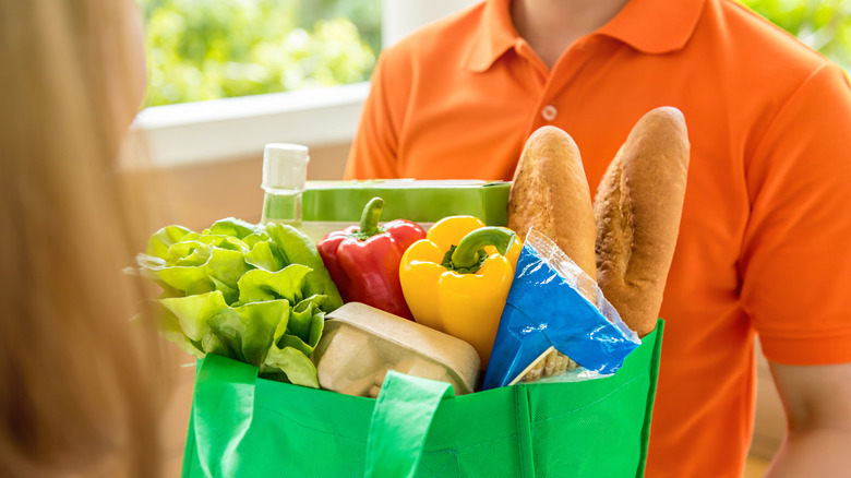 Delivery worker handing a customer a bag of groceries