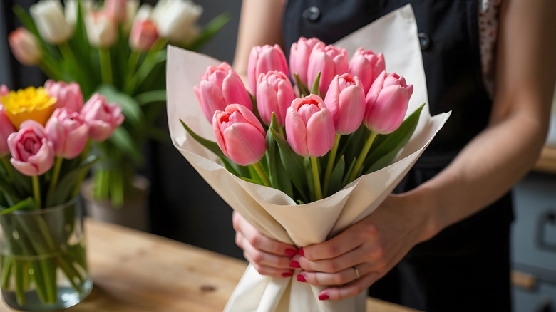 A bouquet of flowers being prepared for delivery