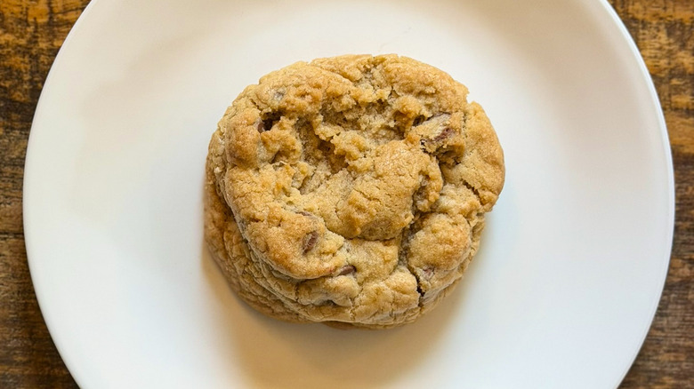 A Crumbl Milk Chocolate Chip Cookie on a white plate