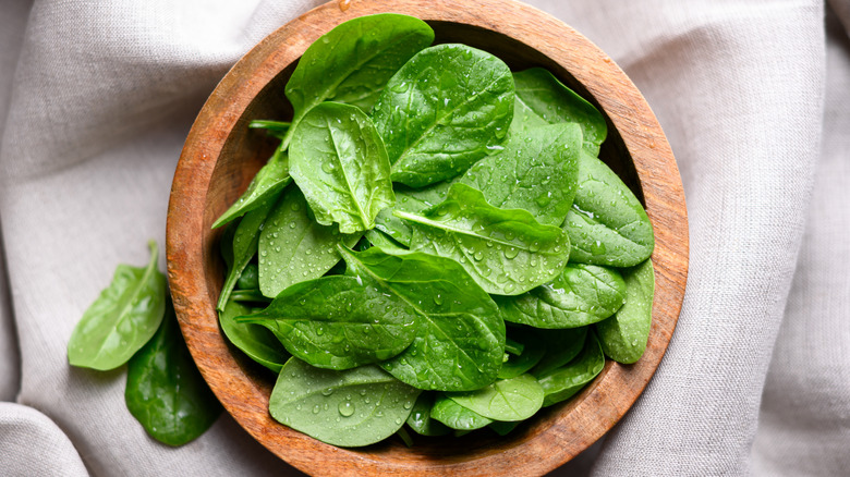 Wooden bowl with baby spinach