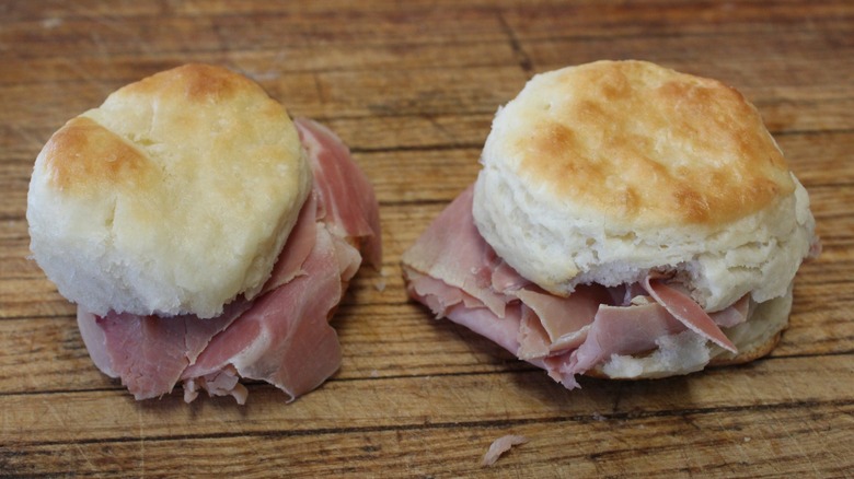 Two buttermilk biscuits with country ham on old wooden table