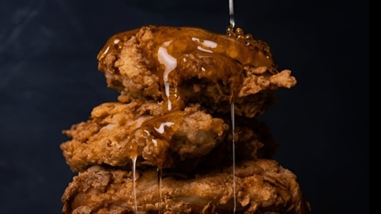 Fried chicken being drizzled with honey