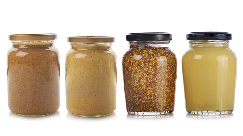 Bottles of mustard isolated on white background